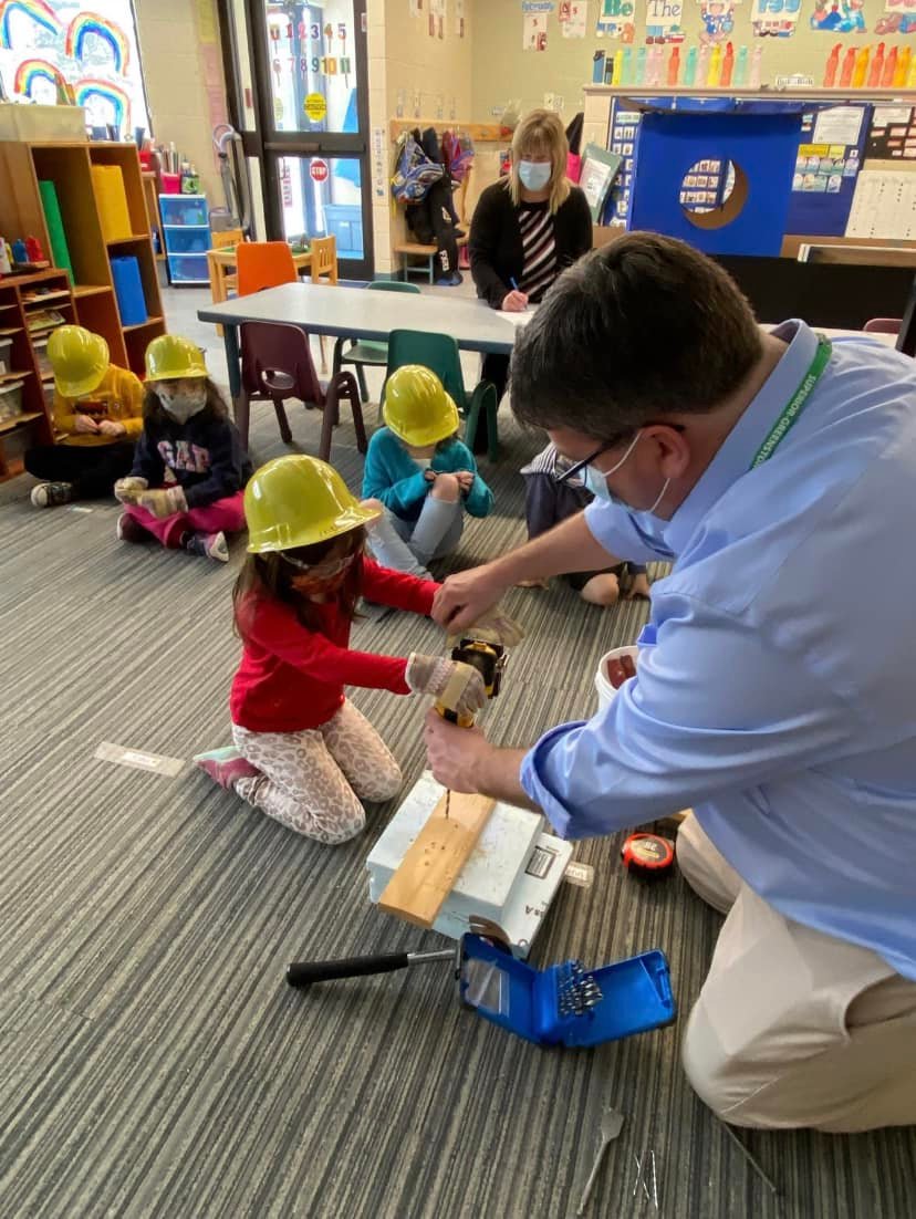 Student working with the Principal on a construction project